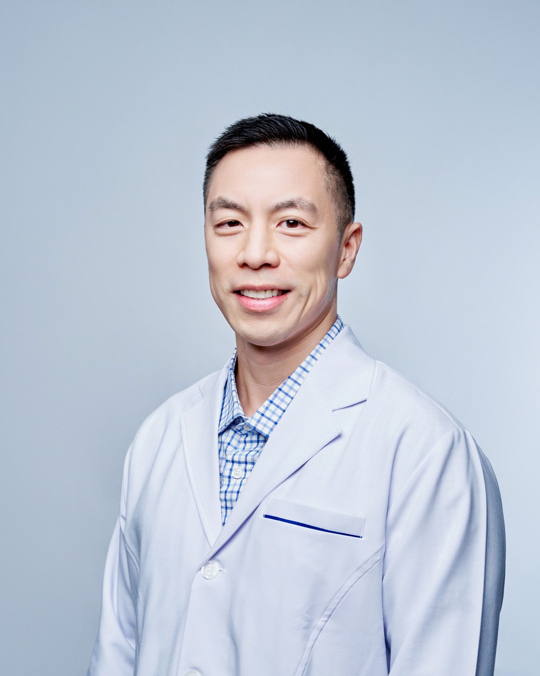 Dr. John Paul Kim, in a white coat, smiling